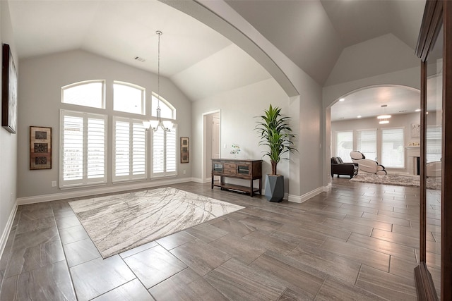 entryway featuring a wealth of natural light, visible vents, a chandelier, and vaulted ceiling