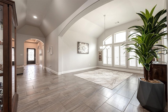 foyer with lofted ceiling, arched walkways, visible vents, and a wealth of natural light