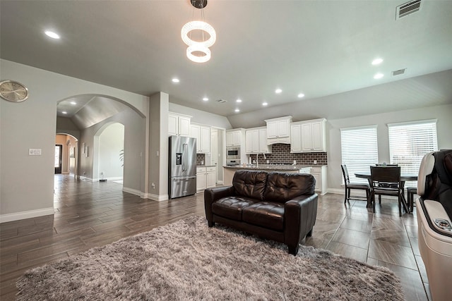 living room featuring recessed lighting, visible vents, arched walkways, and baseboards