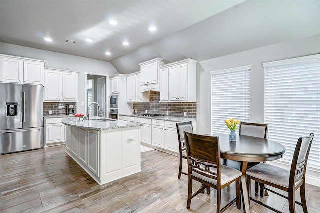 kitchen with visible vents, white cabinets, stainless steel appliances, and a sink