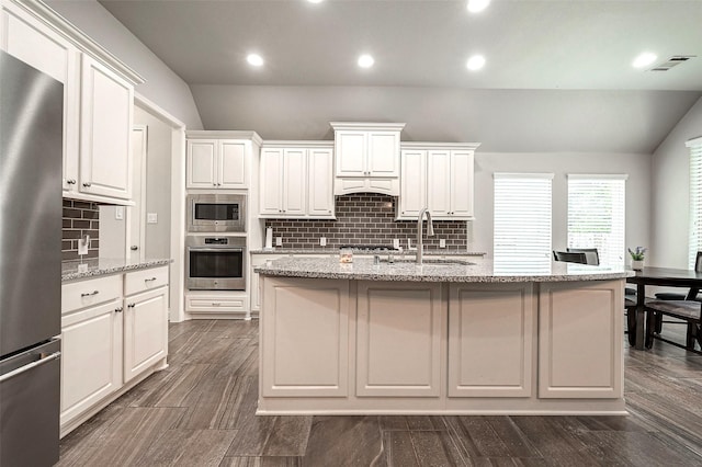 kitchen featuring visible vents, a sink, white cabinetry, appliances with stainless steel finishes, and lofted ceiling