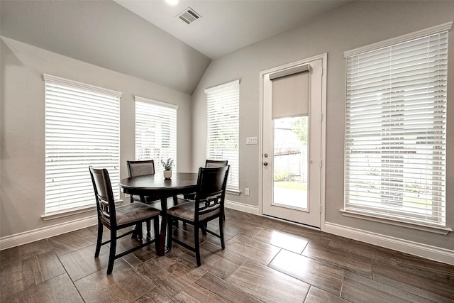 dining room with vaulted ceiling, baseboards, and visible vents