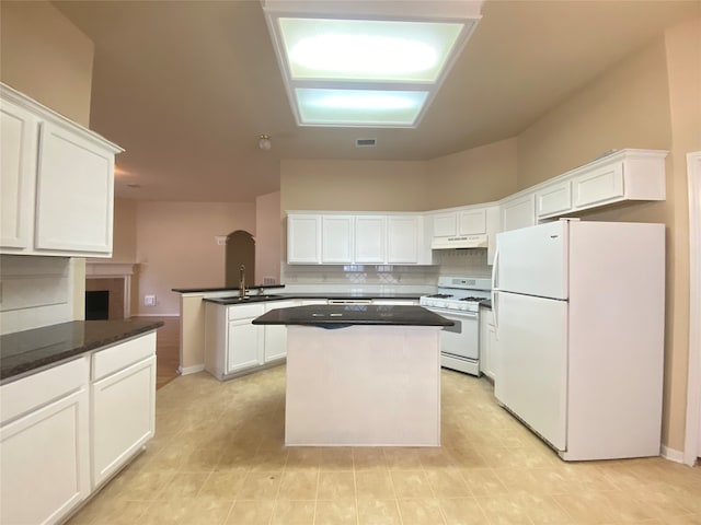 kitchen with sink, white cabinetry, kitchen peninsula, white appliances, and backsplash