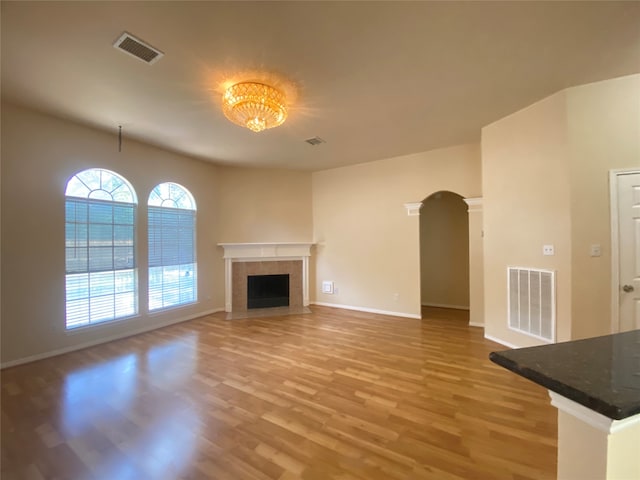 unfurnished living room featuring hardwood / wood-style floors and a tile fireplace