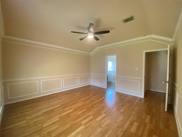 empty room with ceiling fan, vaulted ceiling, ornamental molding, and light hardwood / wood-style floors