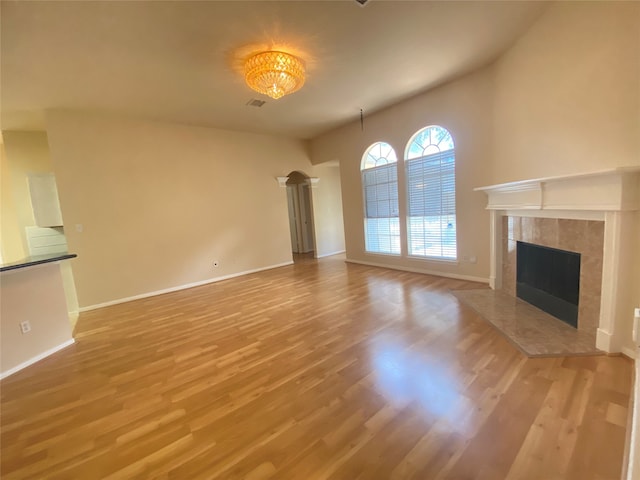 unfurnished living room featuring a tile fireplace and light hardwood / wood-style flooring