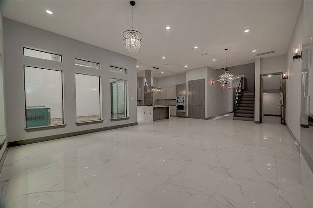 unfurnished living room with a notable chandelier and light tile patterned floors