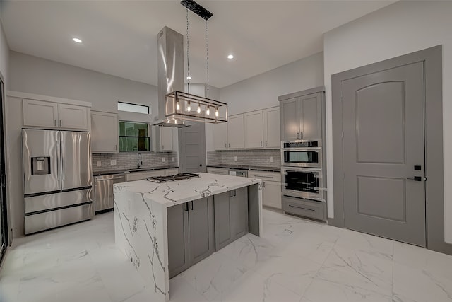 kitchen with stainless steel appliances, backsplash, gray cabinets, a kitchen island, and island exhaust hood