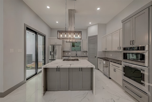 kitchen with a kitchen island, decorative backsplash, stainless steel appliances, and gray cabinets