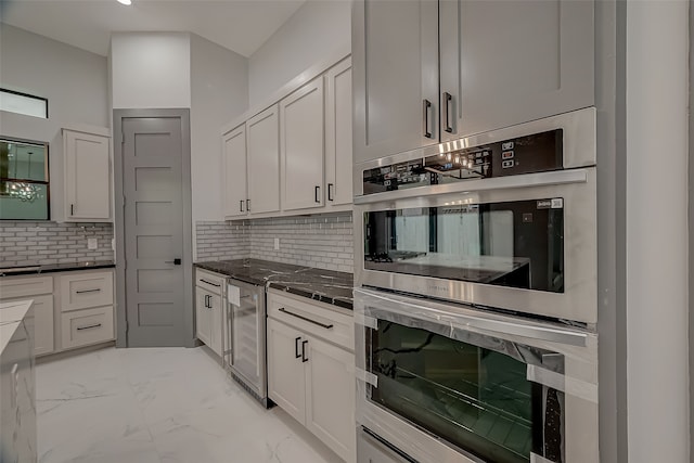 kitchen with double oven, light tile patterned floors, backsplash, and beverage cooler