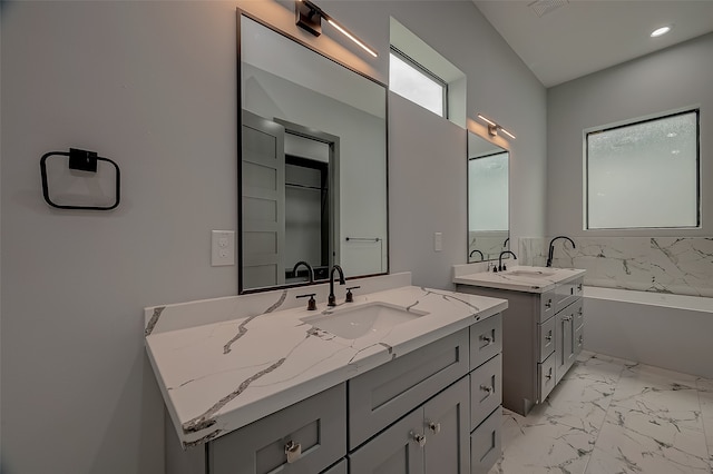 bathroom featuring tile patterned flooring, a tub, and dual vanity