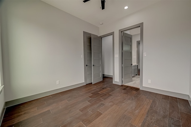 unfurnished bedroom with wood-type flooring, connected bathroom, and ceiling fan