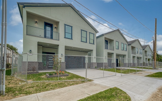 view of front of home featuring a balcony and a front yard