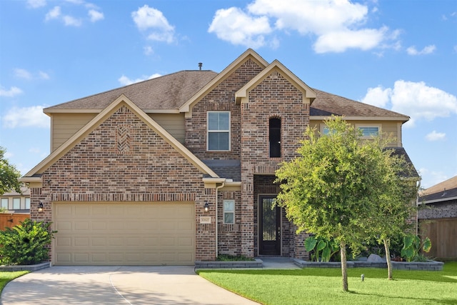 view of property featuring a garage and a front lawn