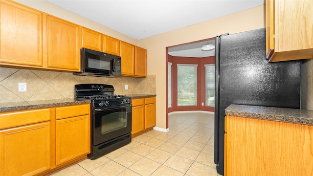 kitchen featuring decorative backsplash, light tile patterned flooring, and black appliances