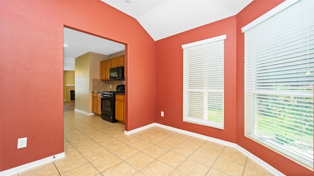 kitchen with black appliances, backsplash, light tile patterned flooring, and vaulted ceiling