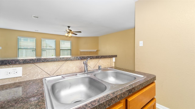 kitchen featuring tasteful backsplash, sink, and ceiling fan