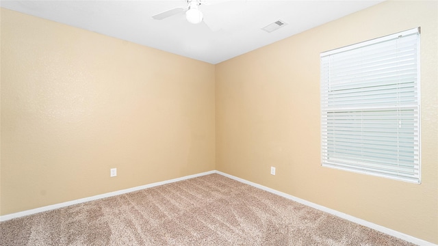 carpeted spare room featuring ceiling fan