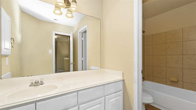 full bathroom featuring a notable chandelier, tiled shower / bath combo, vanity, and toilet