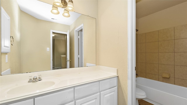 full bathroom with tiled shower / bath, vanity, toilet, and a notable chandelier