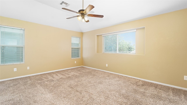 carpeted spare room featuring vaulted ceiling and ceiling fan