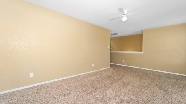 spare room with ceiling fan and carpet