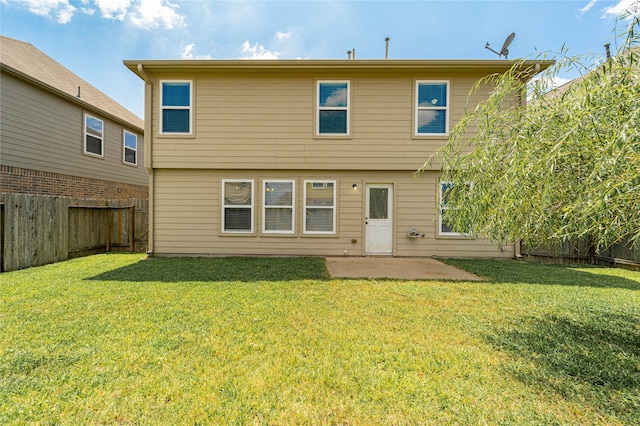 rear view of property featuring a lawn and a patio