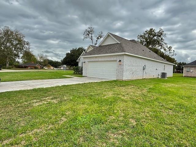 view of property exterior featuring a garage, a yard, and central air condition unit