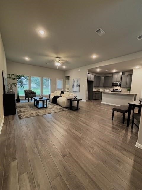 living room featuring ceiling fan and hardwood / wood-style floors