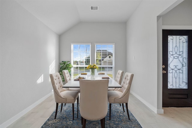 dining room with light hardwood / wood-style floors and lofted ceiling