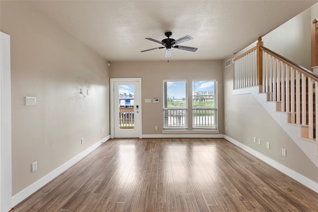 unfurnished living room with a textured ceiling, wood-type flooring, and ceiling fan