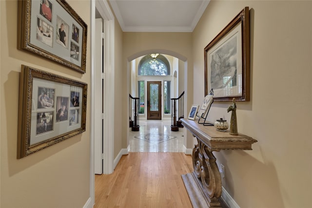 hallway featuring french doors, an inviting chandelier, light hardwood / wood-style flooring, and crown molding