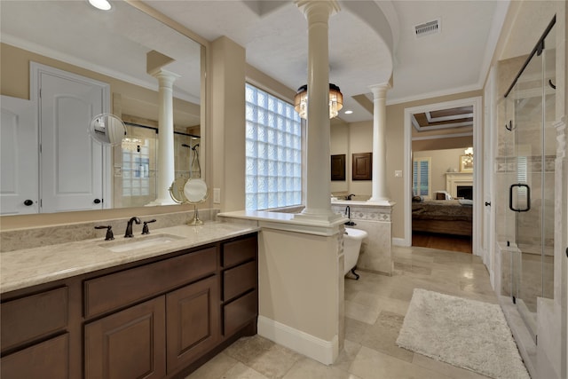 bathroom with decorative columns, a shower with door, vanity, and crown molding