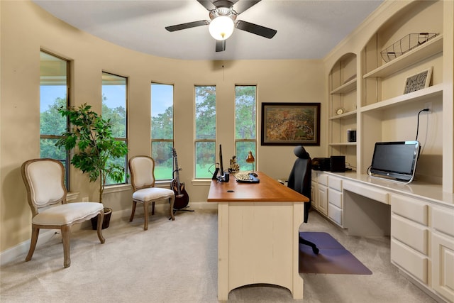 carpeted home office featuring ceiling fan and built in desk