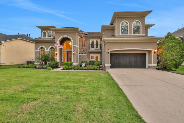 mediterranean / spanish-style home featuring a front lawn, central air condition unit, and a garage