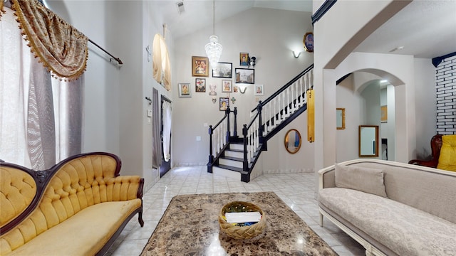 entryway featuring light tile patterned flooring and high vaulted ceiling