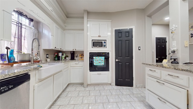 kitchen with appliances with stainless steel finishes, white cabinetry, light tile patterned floors, and light stone counters