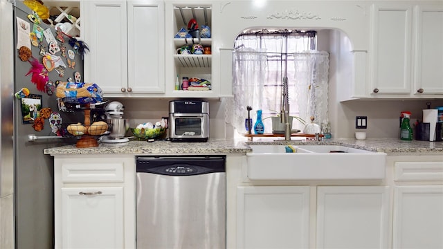 kitchen featuring light stone countertops, white cabinets, and stainless steel appliances