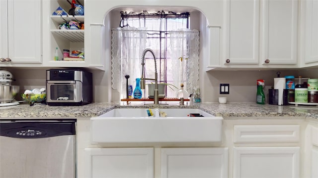 kitchen featuring white cabinetry, dishwasher, and light stone countertops