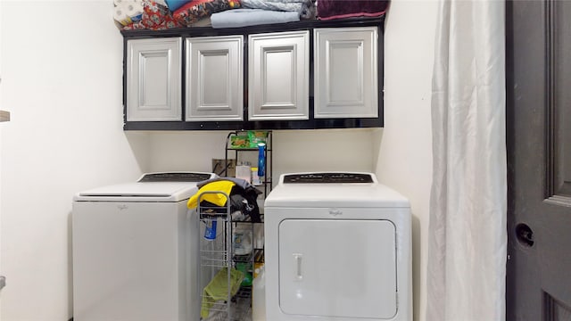 laundry area with independent washer and dryer and cabinets