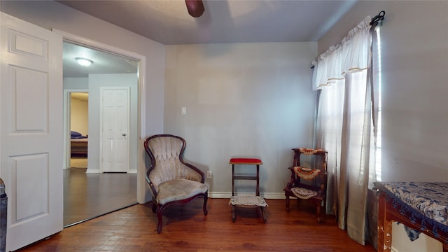 living area with dark hardwood / wood-style flooring and ceiling fan