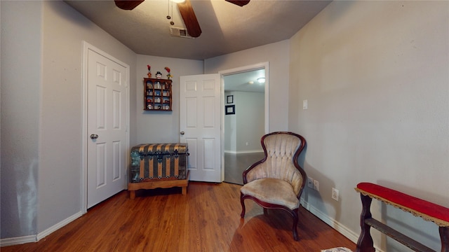 sitting room with wood-type flooring and ceiling fan