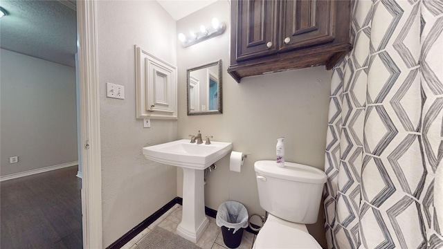 bathroom with toilet and tile patterned floors