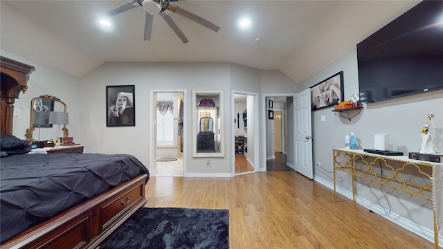 bedroom featuring lofted ceiling, light hardwood / wood-style floors, ensuite bath, and ceiling fan