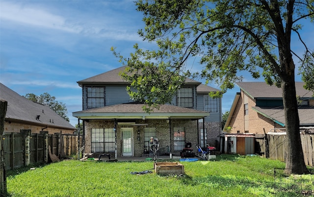 back of house featuring ceiling fan and a lawn