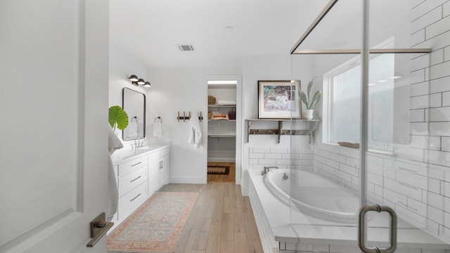 bathroom with vanity, shower with separate bathtub, and hardwood / wood-style floors