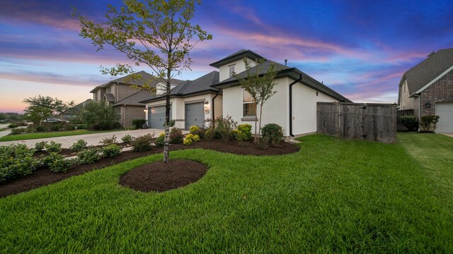 view of front of home with a garage and a yard