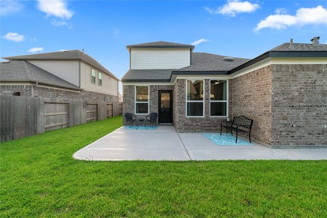 rear view of house with a patio area and a lawn