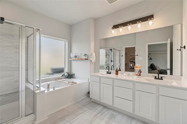 bathroom featuring tile patterned flooring, shower with separate bathtub, and dual bowl vanity