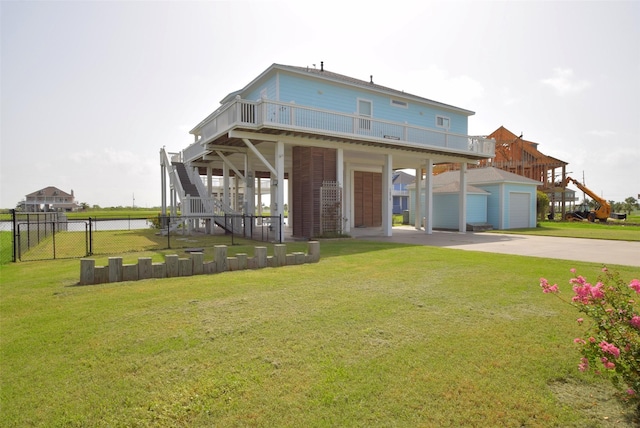 back of house featuring a garage, an outdoor structure, and a lawn